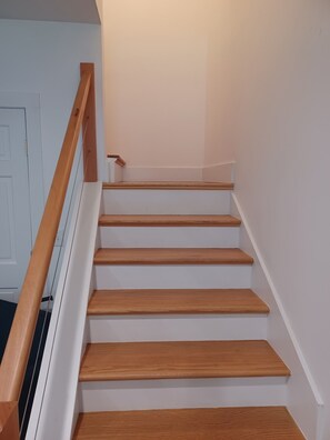 A staircase with wooden steps and a wooden handrail. - Charming 1-bedroom bungalow with AC in Oak Bluffs (Oak Bluffs)