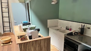 Une cuisine avec une table en bois, un évier et une cuisinière.