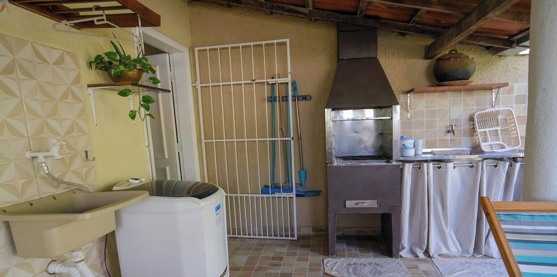 A compact kitchen with a sink, a stove, and a pot on the stove.