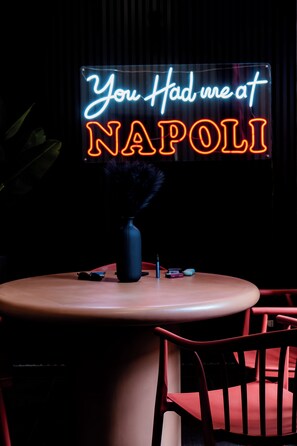 A table with a neon sign that reads 'You Had Me at NAPOLI' and a vase with feathers. - LH51 Urban Suite – Design & Luxury in the Historic Center of Naples (Napoli)