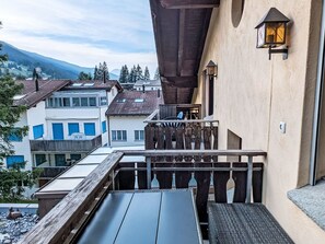 Ein Balkon mit Blick auf benachbarte Gebäude und einen Berg im Hintergrund.