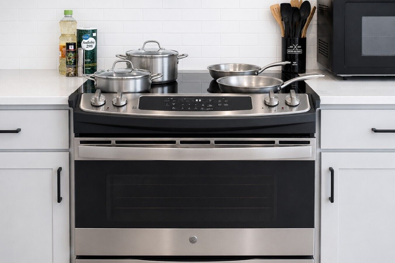 A kitchen with a stainless steel stove, oven, and pots.