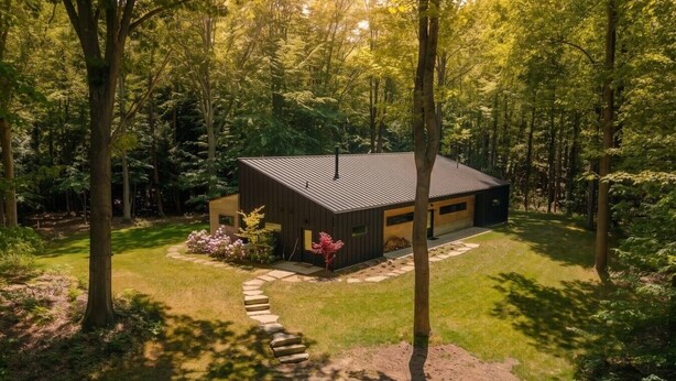 A modern house surrounded by a forest.