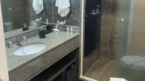 Ein modernes Badezimmer mit zwei Waschbecken, einem großen Spiegel und einer Duschkabine.