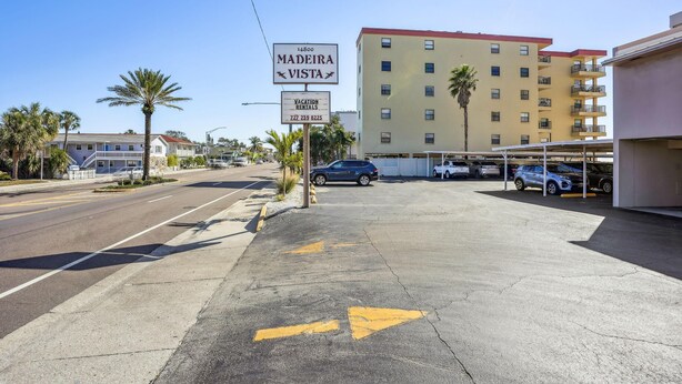 Un estacionamiento con un letrero que dice 'Madeira Vista' y un letrero de 'Vacation Rentals'.