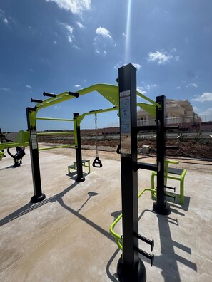 An outdoor gym with exercise equipment, including pull-up bars and a bench. - Largest 2 Bedroom Oceanview Rooftop Apartment in Borto 84 (Sicilia)