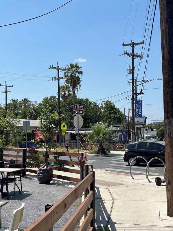 A street view with a pedestrian crossing, a sign for 'S Alamo Cedar', and a 'Fresh Milk' sign.