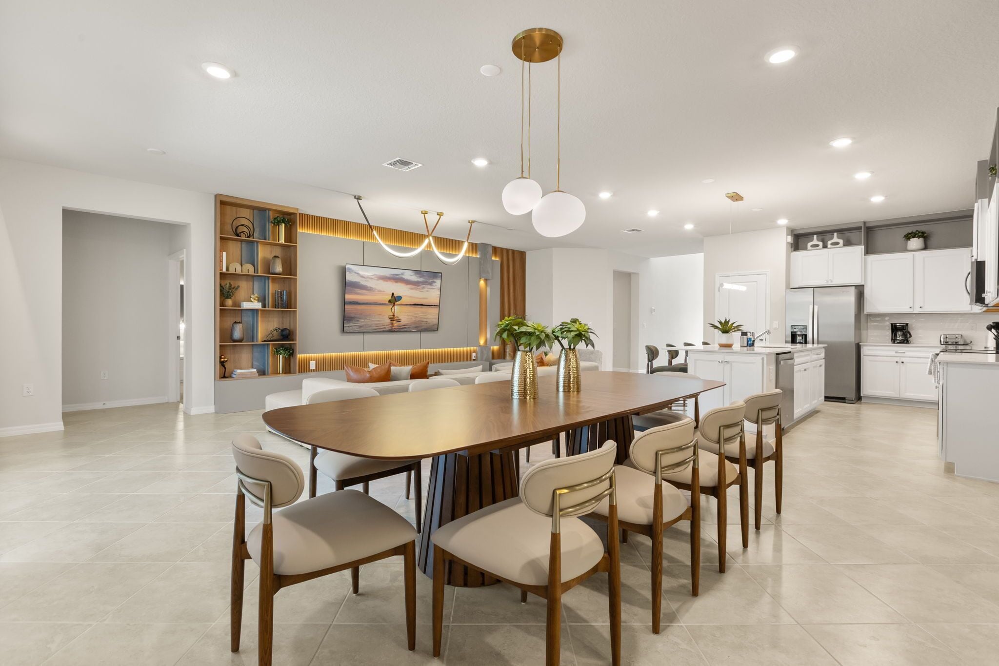 Een moderne keuken met witte kasten, een centraal eiland en een eethoek met een houten tafel en stoelen.