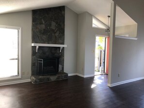 A room with a stone fireplace, hardwood flooring, and a view through an open door. - gorgeous house central to shopping, military  base and hospitals. Best schools (Fayetteville)