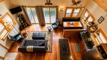 A spacious living area with a sofa, a dining table, and a kitchen area with a stove and refrigerator.