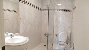 A bathroom with a glass-enclosed shower, a white sink, and a toilet. - Cambrils-Salou Beach A (Cambrils)
