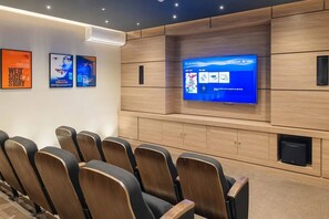 Une salle de cinéma moderne dotée d’un grand écran, de sièges confortables et d’un lecteur de disques Blu-ray.