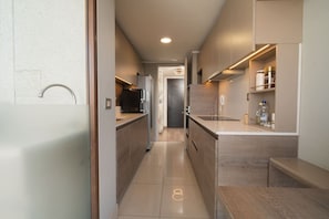 A modern kitchen with a central island, built-in appliances, and a minimalist design. - Andes view - A/C, pool, BBQ grill & free parking (Providencia)