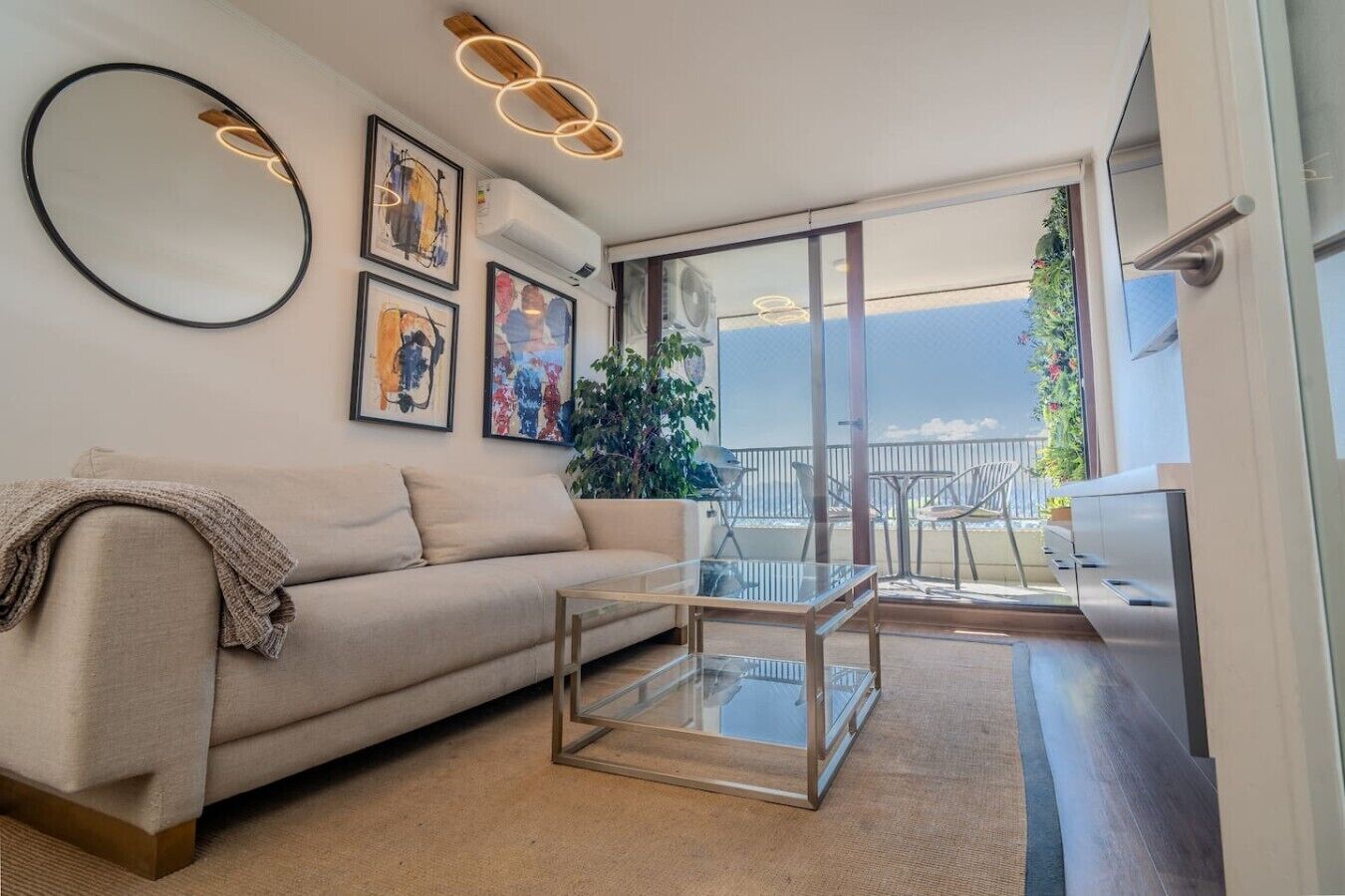Ein modernes Wohnzimmer mit Sofa, Couchtisch und einem Kunstwerk an der Wand.