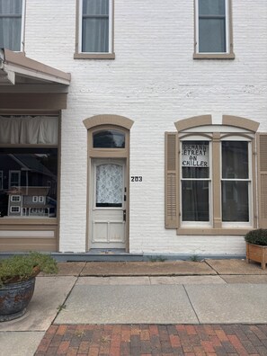 A white building with a double door, a window with shutters, and a sign that reads 'ERMANN RETREAT ON CHILLER'.