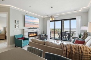 A living room with a fireplace, a ceiling fan, and a large TV. - Penthouse Main Channel Views, Resort Pools & Boat Slip at Topsider's 19mm (Osage Beach)