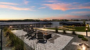 An outdoor patio area with seating and a fire pit, overlooking a body of water and a distant shoreline. - Penthouse Main Channel Views, Resort Pools & Boat Slip at Topsider's 19mm (Osage Beach)
