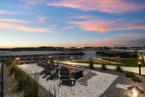 An outdoor patio area with seating and a fire pit, overlooking a body of water and a distant shoreline. - Penthouse Main Channel Views, Resort Pools & Boat Slip at Topsider's 19mm (Osage Beach)