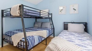 A bunk bed room with a lower bunk, a single bed, and two framed bird pictures on the wall. - Family-friendly Condo at the 1MM Boat Slip, Lake Views + Pool Access Near Bagnell Dam (Lake Ozark)