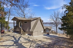Eine Hütte mit Veranda, Treppe und Seeblick.