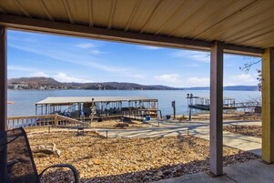 Un espacio al aire libre techado con vistas a un lago y colinas distantes.