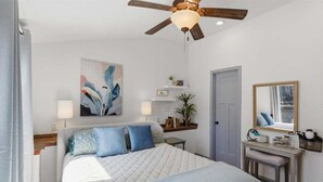 A bedroom with a bed, a ceiling fan, a painting, a bedside table, a mirror, and a door. - Zero-step Dock Life With Big Views, Lake Toys, Firepit, Boat Slip at 43mm (Roach)