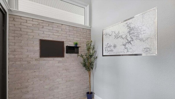 Ein Zimmer mit Backsteinwand, einer aufgehängten Karte, einem Blumentopf und einem kleinen Regal mit einer Pflanze.