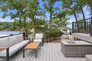 A deck with outdoor furniture, a railing, and a view of a lake. - Private Dock, Boat & PWC Slips, Fire Pit, Lake Views (Rocky Mount)