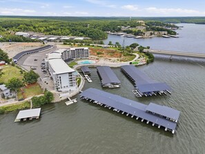Ein Hotel am Flussufer mit mehreren vertäuten Booten, einem Schwimmbad und einem großen Gebäude mit gewölbtem Dach.