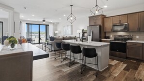 A modern kitchen with a central island, bar stools, and a large window overlooking a scenic view. - Main Channel Views, Resort Pools & Boat Slip at Topsider's 19mm (Osage Beach)