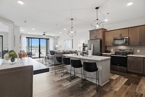 A modern kitchen with a central island, bar stools, and a large window overlooking a scenic view. - Main Channel Views, Resort Pools & Boat Slip at Topsider's 19mm (Osage Beach)