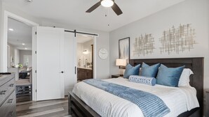 A bedroom with a bed, a nightstand, a lamp, a clock, and a ceiling fan. - Main Channel Views, Resort Pools & Boat Slip at Topsider's 19mm (Osage Beach)
