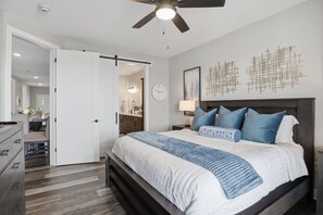 A bedroom with a bed, a nightstand, a lamp, a clock, and a ceiling fan. - Main Channel Views, Resort Pools & Boat Slip at Topsider's 19mm (Osage Beach)