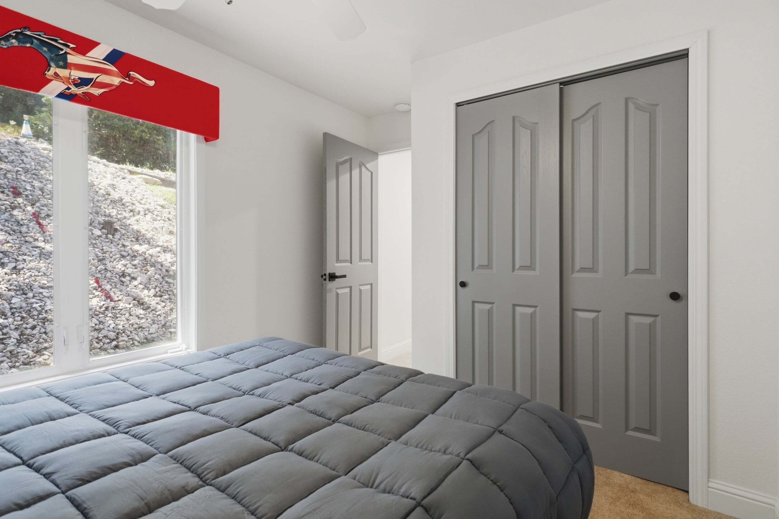 Un dormitorio con una cama, una ventana y una puerta.