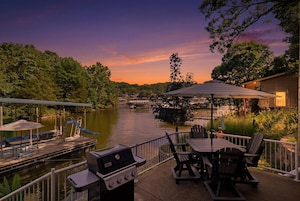 A riverside patio with a grill, tables, chairs, and a covered area.