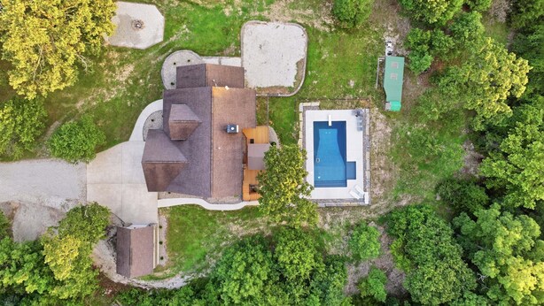 An aerial view of a residential property with a swimming pool, a detached garage, and a large lawn area. - Private Heated Pool, Sleeps 18, Game Room & Outdoor Living (Camdenton)