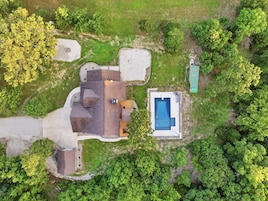 Vista aérea de una propiedad residencial con piscina, garaje independiente y amplio césped.