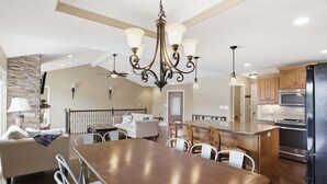 A spacious kitchen with a large island, modern appliances, and a chandelier. - Perfect Lake Life at Bulldog Lake House! Huge Dock, Dock Bar, Decks & Fun at 2mm! (Lake Ozark)