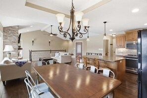 A spacious kitchen with a large island, modern appliances, and a chandelier. - Perfect Lake Life at Bulldog Lake House! Huge Dock, Dock Bar, Decks & Fun at 2mm! (Lake Ozark)
