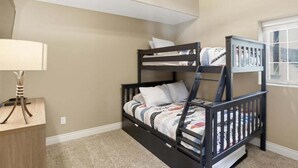 A bunk bed with a desk and lamp, beige walls, and a window with a view. - Perfect Lake Life at Bulldog Lake House! Huge Dock, Dock Bar, Decks & Fun at 2mm! (Lake Ozark)