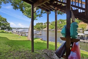 Blick auf einen Fluss mit Holzterrasse, einer Brücke und einem Bootsanleger.