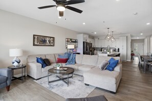 A modern living room with a sofa, coffee table, and a ceiling fan. - Main Channel Views, Resort Pools & Boat Slip at Topsider's 19mm (Osage Beach)