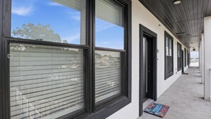 A building with large windows, a covered walkway, and a welcome mat. - Main Channel Views, Resort Pools & Boat Slip at Topsider's 19mm (Osage Beach)