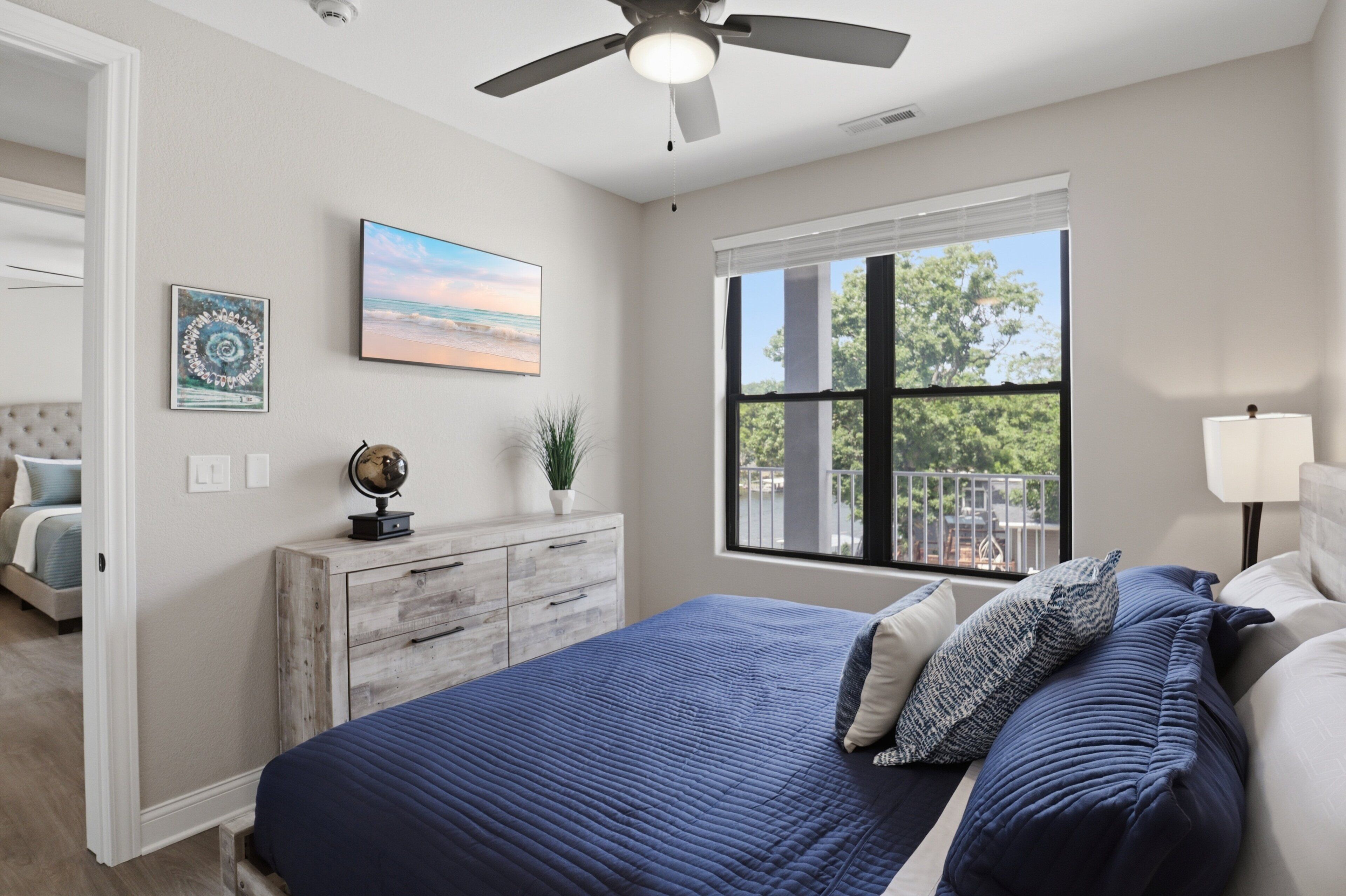 Une chambre à coucher avec un lit, une commode, un globe terrestre et un tableau.