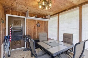 A room with a wooden interior, a table with chairs, a star decoration, and a ceiling fan.