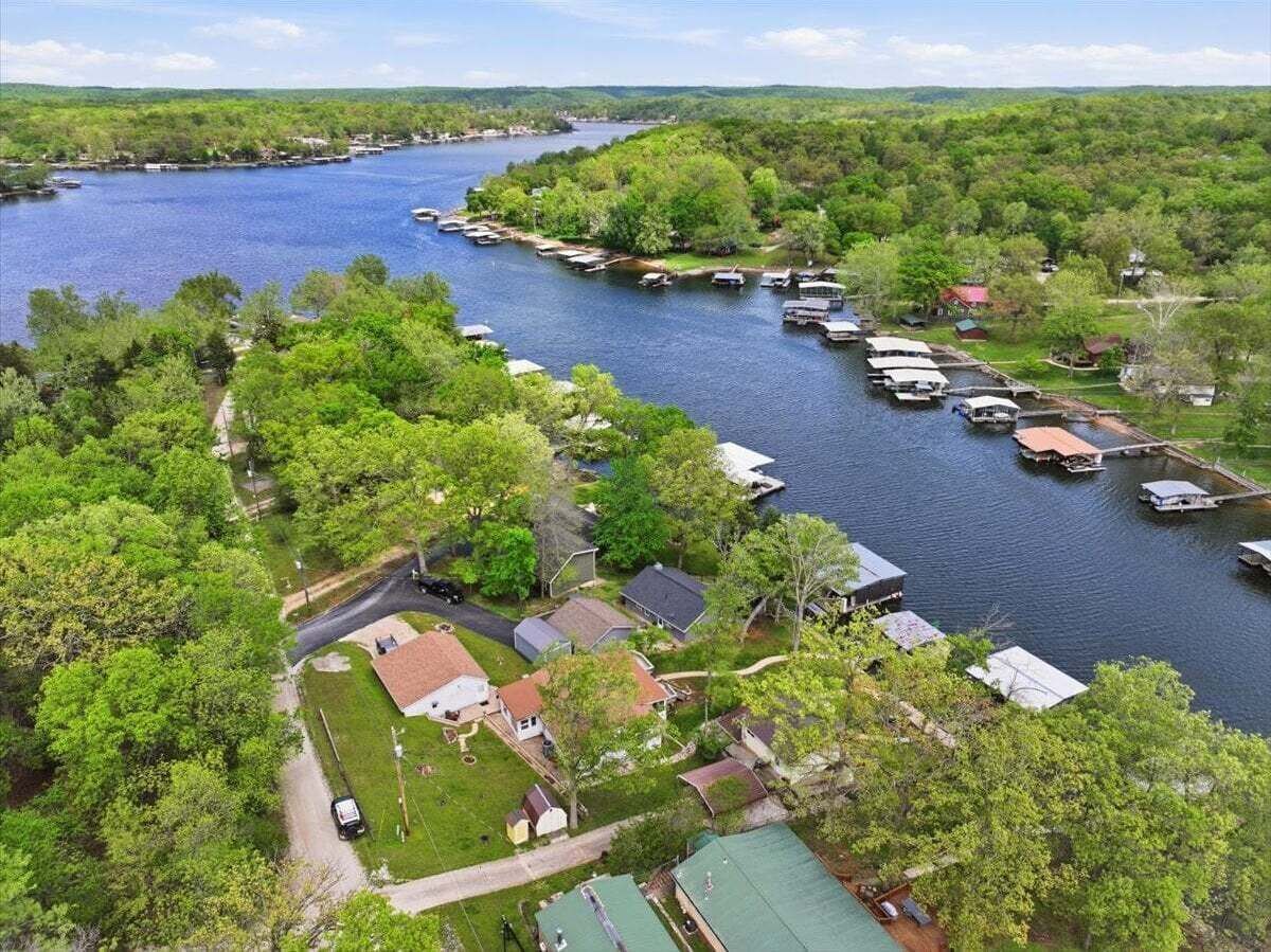 A lakeside property with boats docked, a dock, and a small building.
