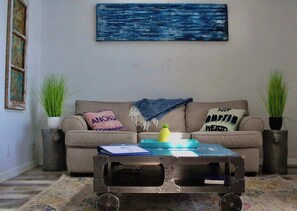 A living room with a sofa, two side tables, a coffee table, and a painting on the wall. - Right on the water! Lake Travis (Spicewood)