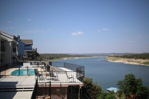 A pool area with a view of a river and distant hills. - Right on the water! Lake Travis (Spicewood)