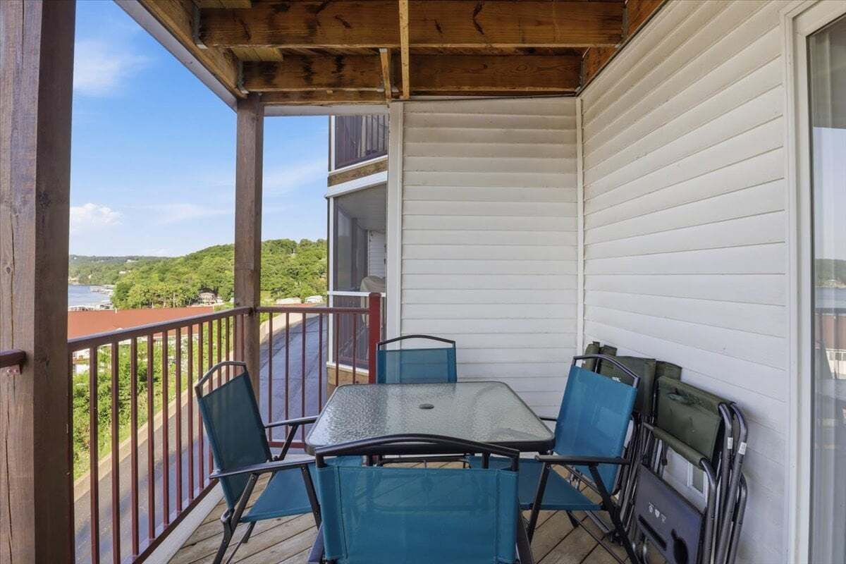En balkon med bord og stole, der giver udsigt over et smukt landskab.