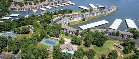 Ett flygbildsbild av en fastighet vid vattnet med flera byggnader, bryggor och grönområden.